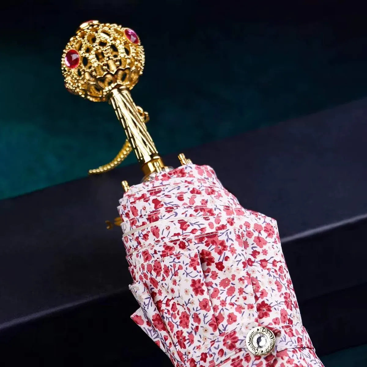 The flower folding umbrella with a jeweled handle, shown closed in a light floral pattern.