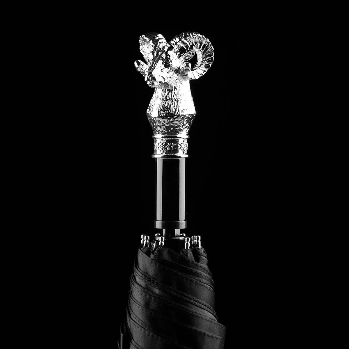 The silver animal head folding umbrella featuring the intricately detailed Ram handle against a black background.