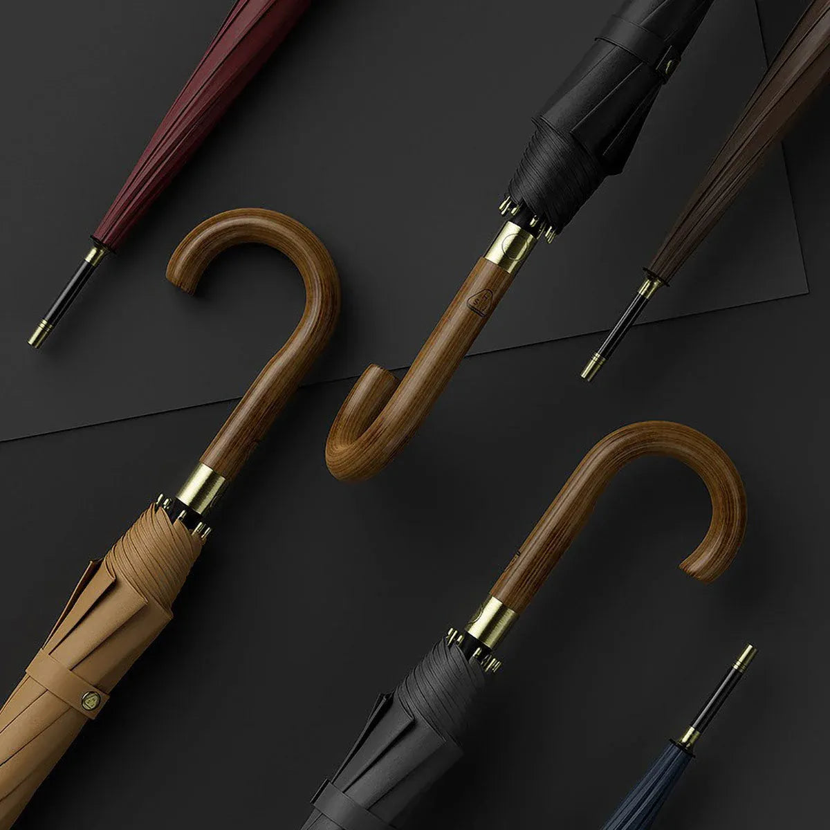 Stylish long umbrellas with curved wooden handles in various colors on dark background