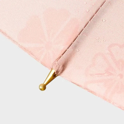 Detail shot of the wet canopy tip, showing the faint floral pattern that appears when the umbrella gets wet.