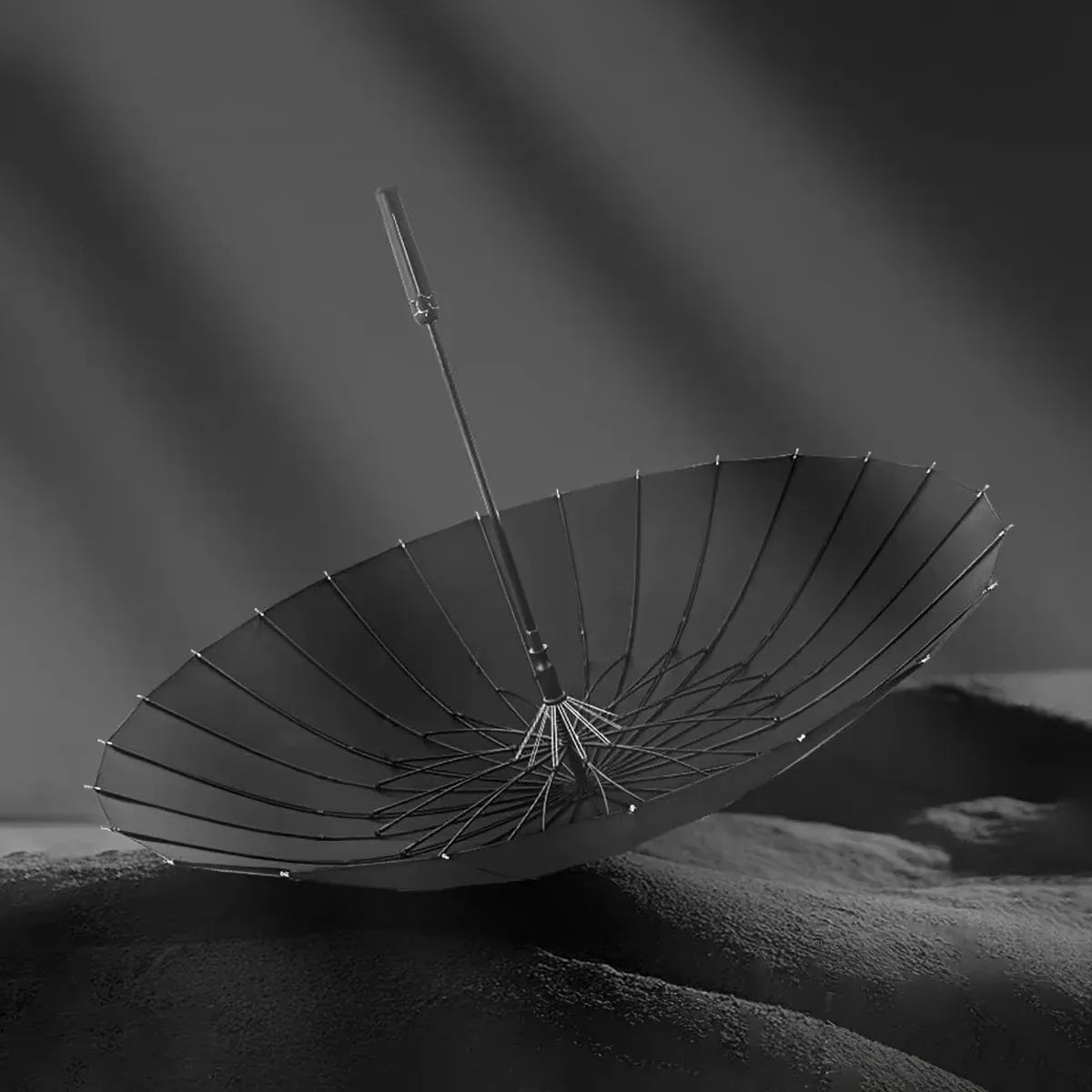 Dramatic view of the open black canopy and durable fiberglass structure of the 24-rib storm umbrella.