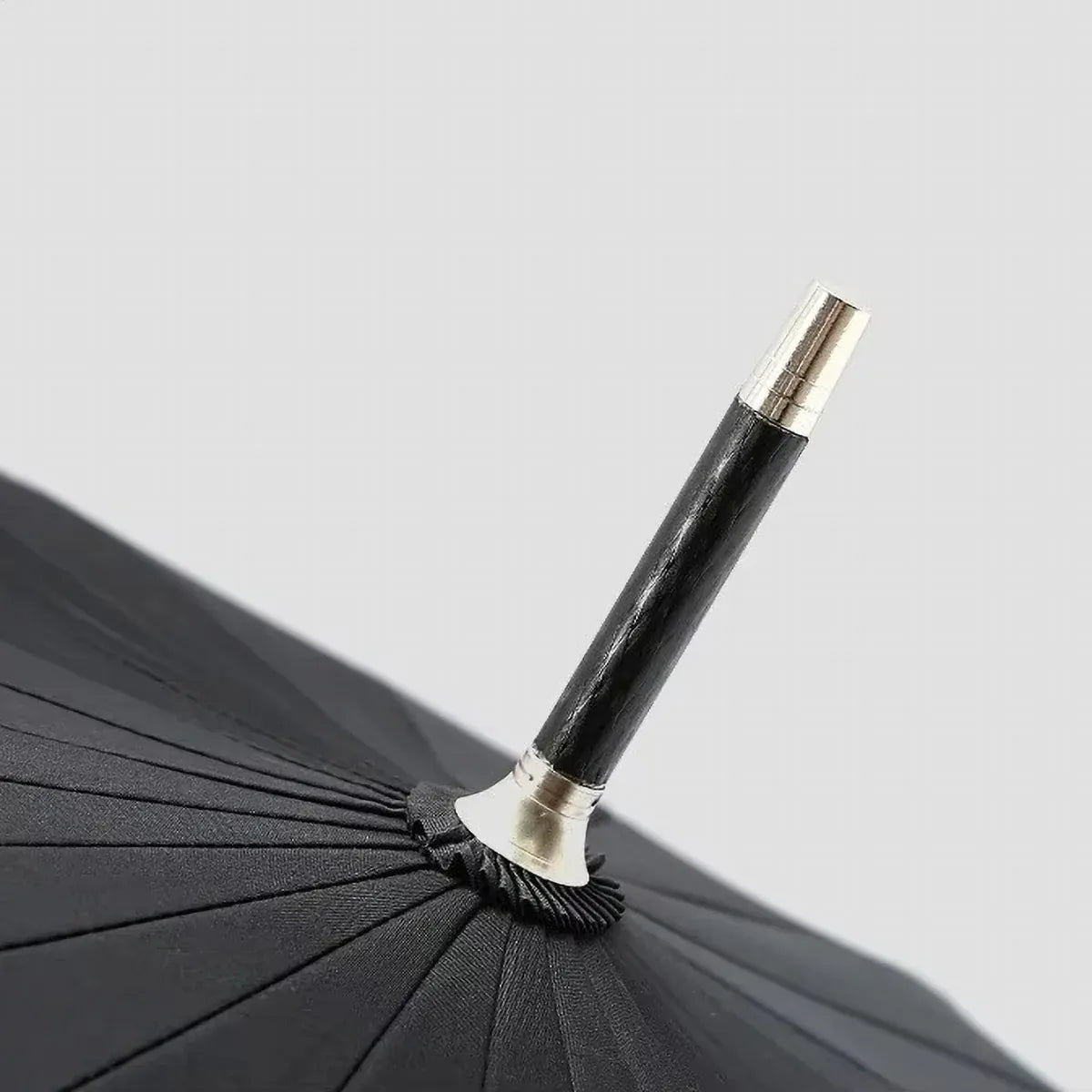 Close-up view of the top ferrule tip of the closed 24-rib umbrella.