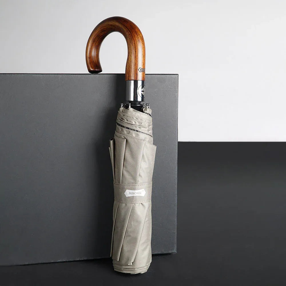 Profile view of the closed 48-inch khaki umbrella with a wooden hook handle, standing upright.