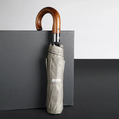 Profile view of the closed 48-inch khaki umbrella with a wooden hook handle, standing upright.