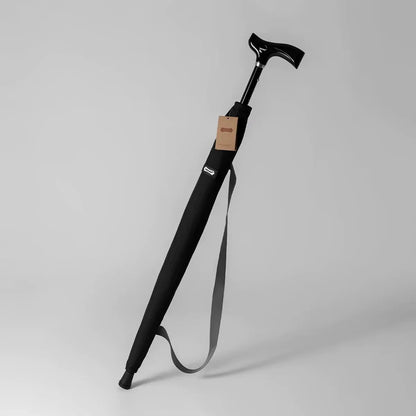 The adjustable walking stick umbrella in black, shown in its carrying sleeve with a shoulder strap.