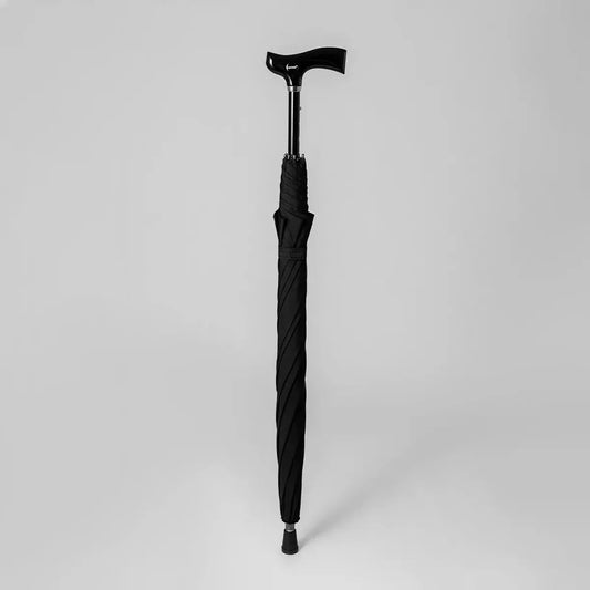Profile view of the black adjustable walking stick umbrella when closed, showing the ergonomic derby handle.