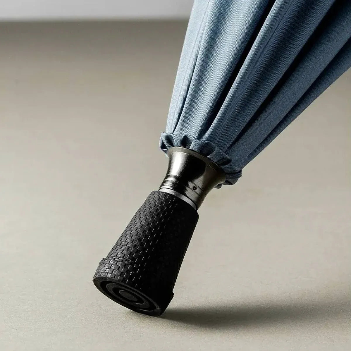 Detailed close-up of the non-slip textured rubber tip of the walking cane umbrella for enhanced safety.
