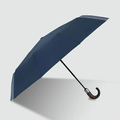 Full view of the navy blue 10-rib automatic folding umbrella with a natural wood hook handle.