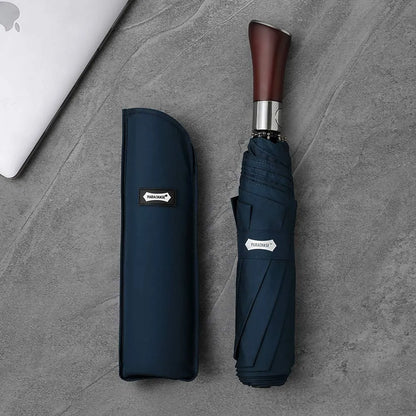 The large 48-inch automatic folding umbrella in navy blue, shown closed with its matching carrying sleeve.