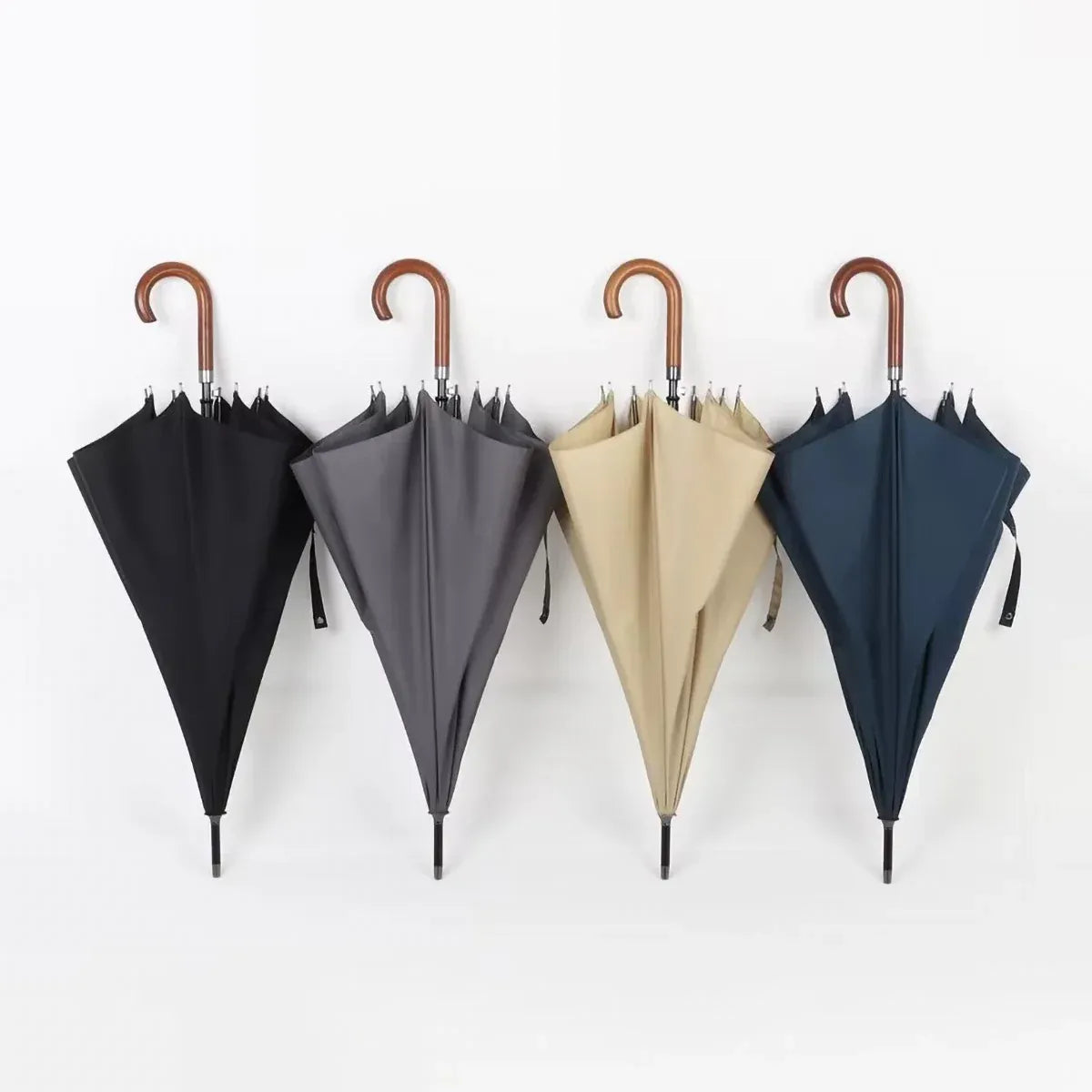 All four color options of the classic stick umbrella with wooden crook handles, hanging closed.
