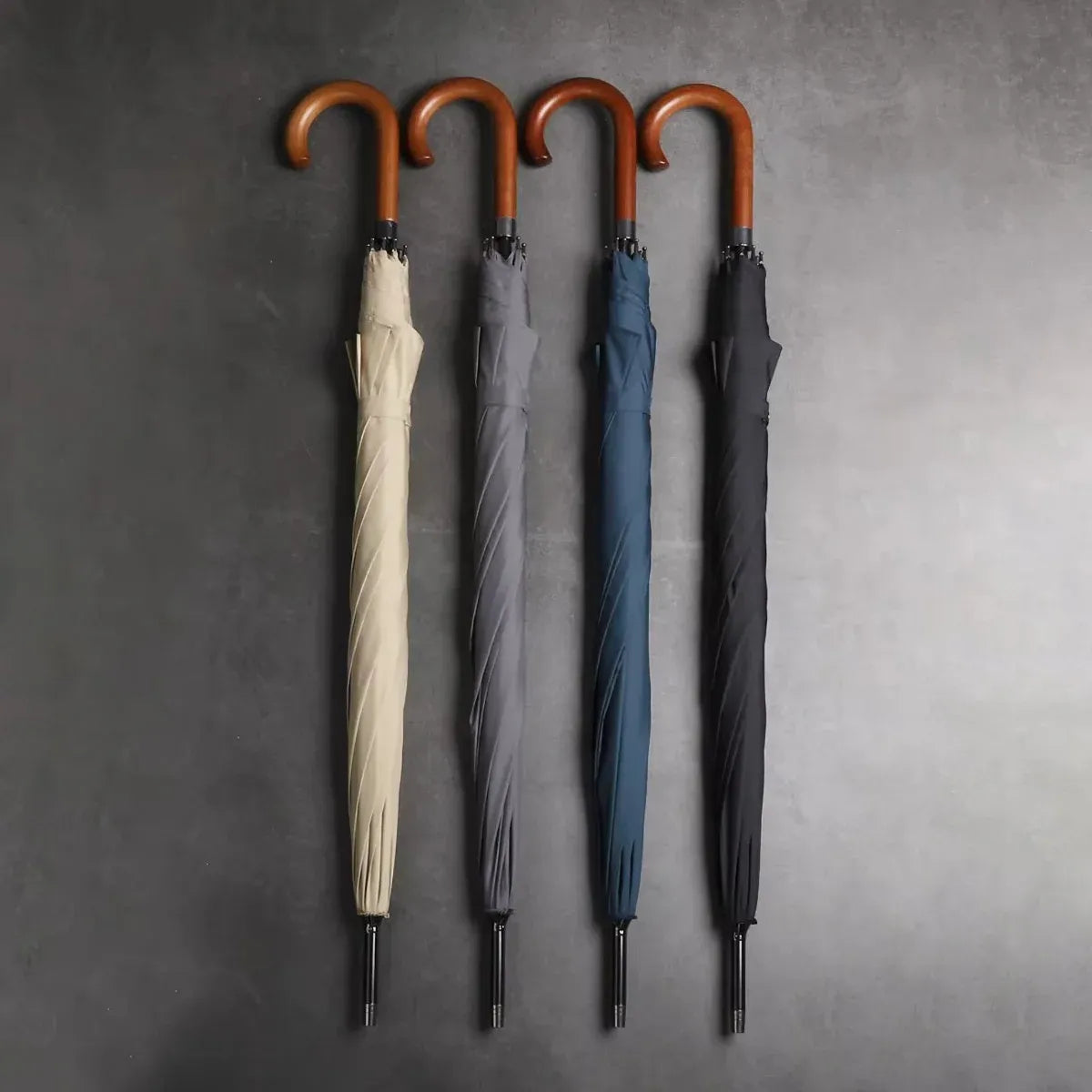 All four color options (beige, grey, blue, black) of the classic stick umbrella standing closed in a row.