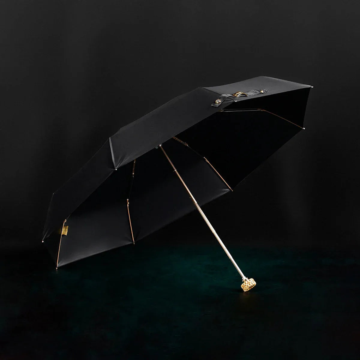 Full view of the open black compact luxury mini umbrella with its crystal handle.