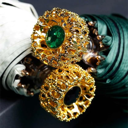 Detailed close-up of the ornate golden crystal handles in green and black stone variants.