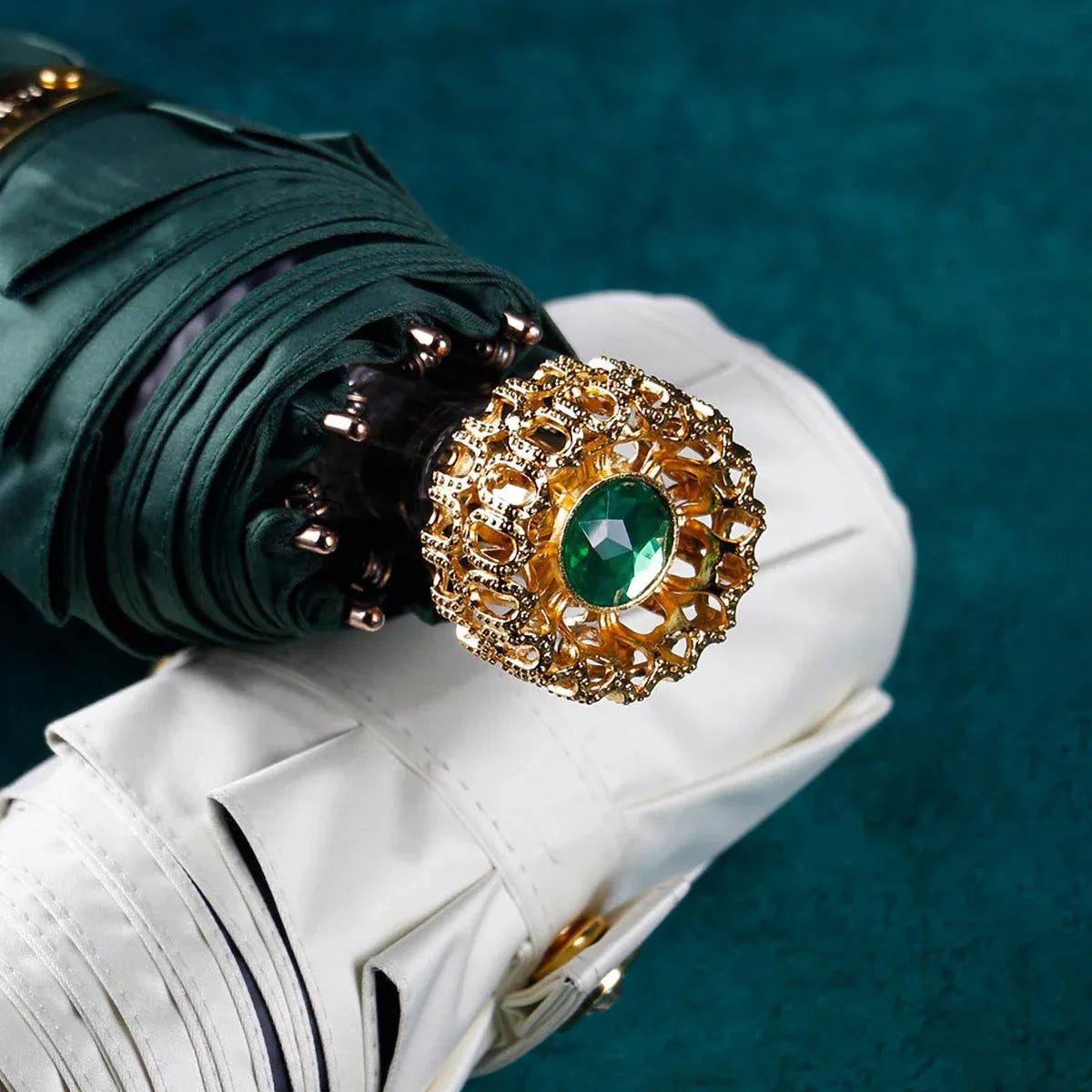 Top-down close-up of the ornate golden handle with an emerald green crystal.