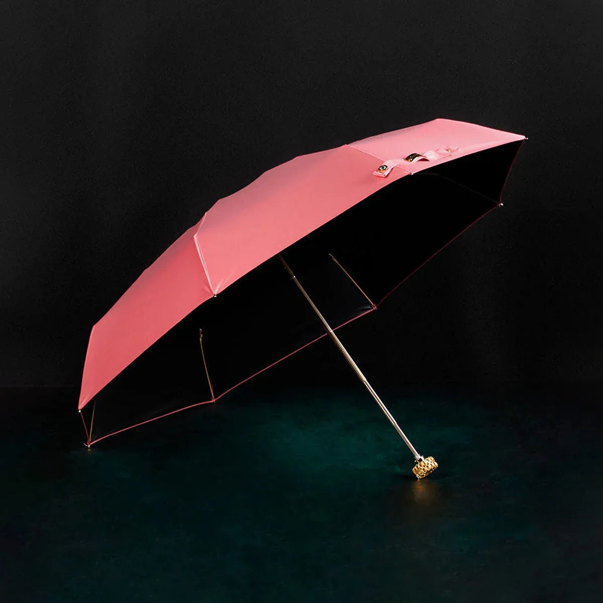 Full view of the open pink compact luxury mini umbrella with its crystal handle.