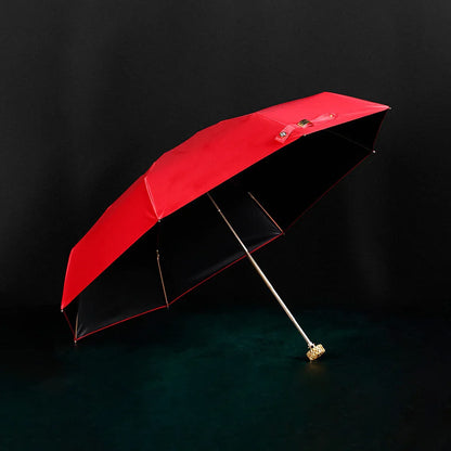 Full view of the open red compact luxury mini umbrella with its crystal handle.