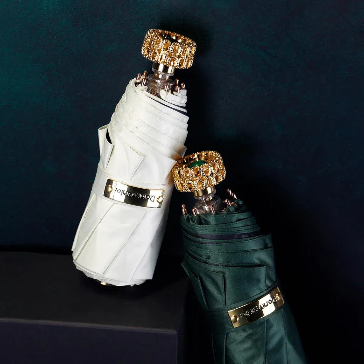 Lifestyle shot of the white and green compact luxury mini umbrellas closed, leaning together.