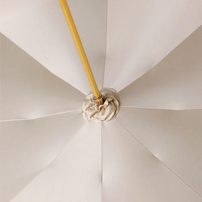 View looking up inside the white canopy, showing the central mechanism and fabric details.