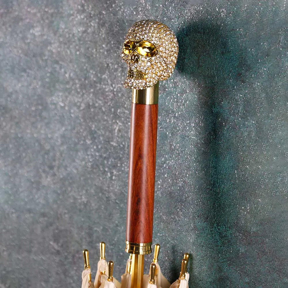 Detailed close-up of the glamorous, crystal-encrusted golden skull handle on the wooden shaft.