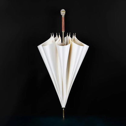 The white Diamond Skull stick umbrella standing closed against a black background.