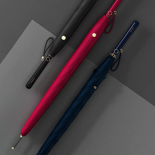 Lifestyle arrangement of the elegant long handle umbrellas closed, in black, red, and navy.