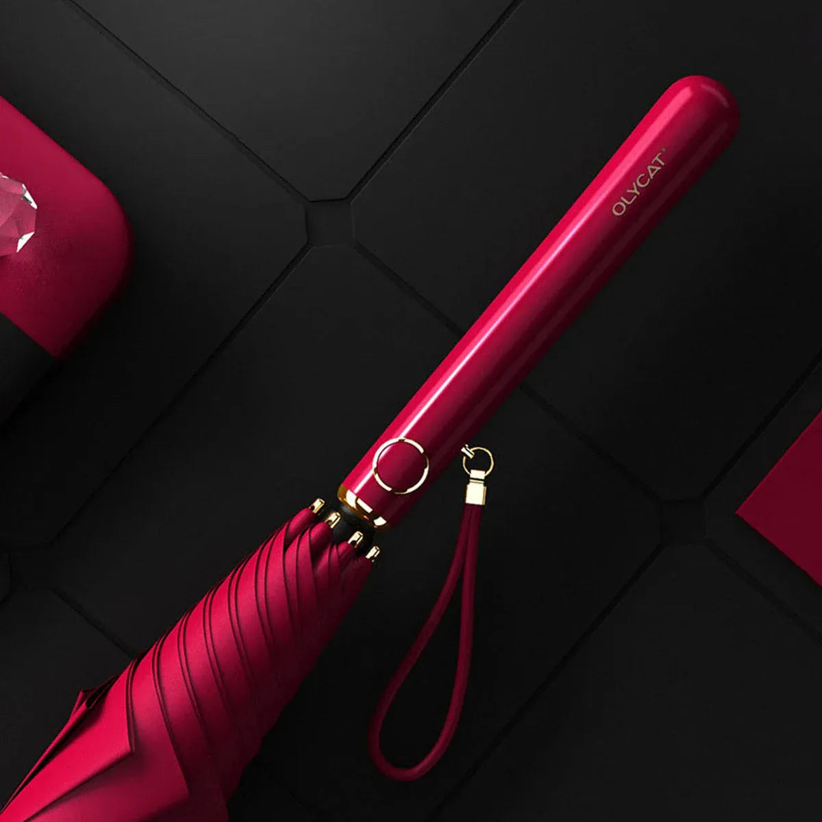 Close-up of the sleek red plastic handle with gold accents and wrist strap.