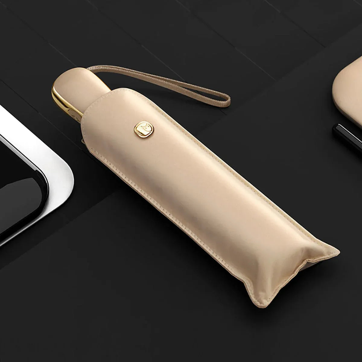 The elegant automatic travel umbrella for women in beige, shown closed in its matching sleeve.