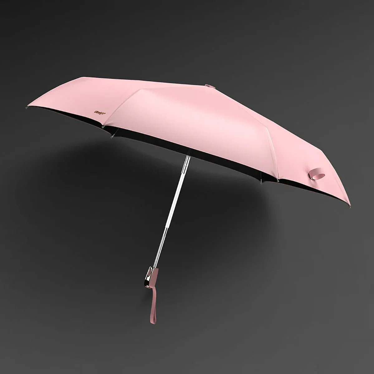 The lightweight elegant travel umbrella for women shown open in pink color against a dark background.