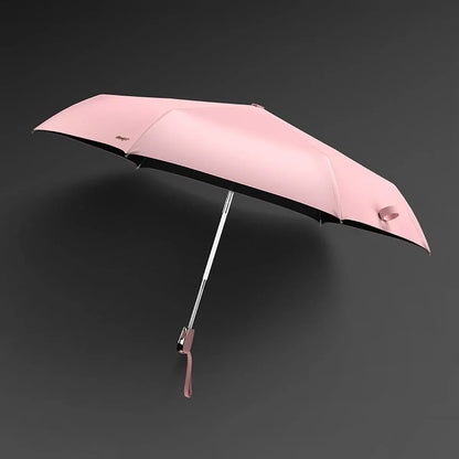 The lightweight elegant travel umbrella for women shown open in pink color against a dark background.