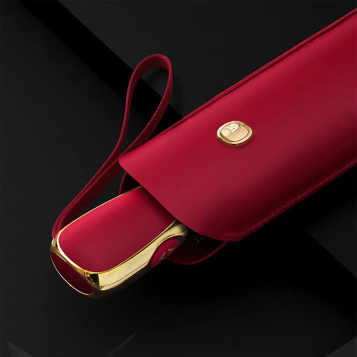 Detail shot of the red travel umbrella handle partially emerging from its matching sleeve.