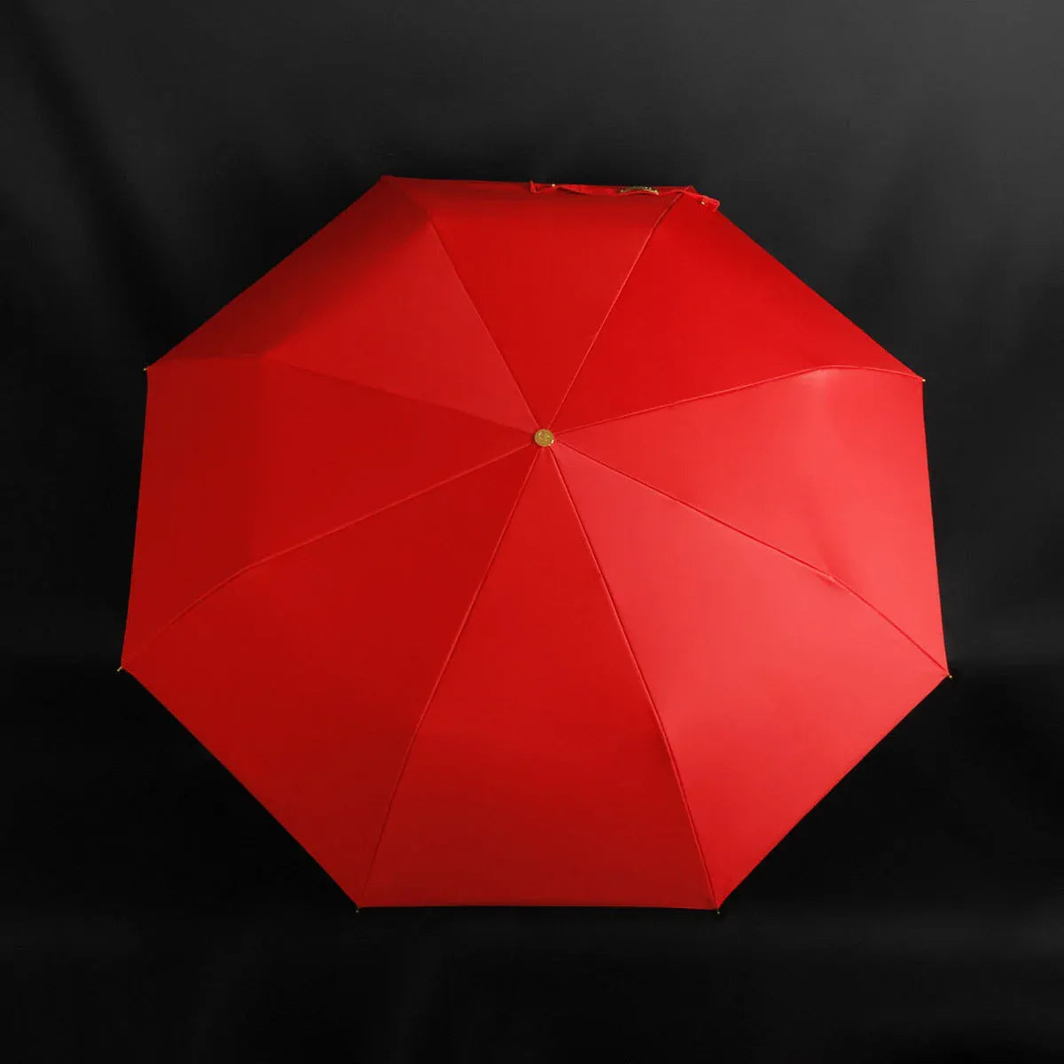 Top-down view of the vibrant red open canopy of the scorpion handle umbrella.
