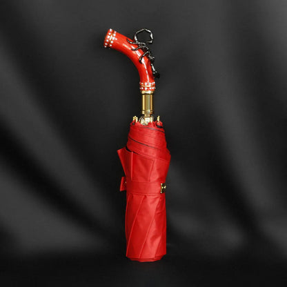Profile view of the closed fancy red umbrella, showcasing the striking black scorpion handle.
