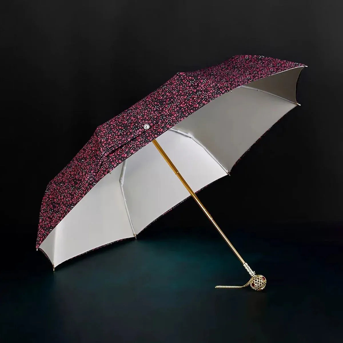 Full view of the open flower folding umbrella in the dark floral pattern with jeweled handle.