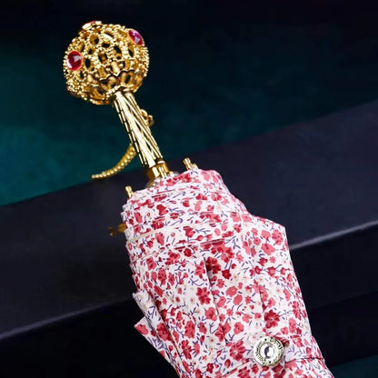 The flower folding umbrella with a jeweled handle, shown closed in a light floral pattern.