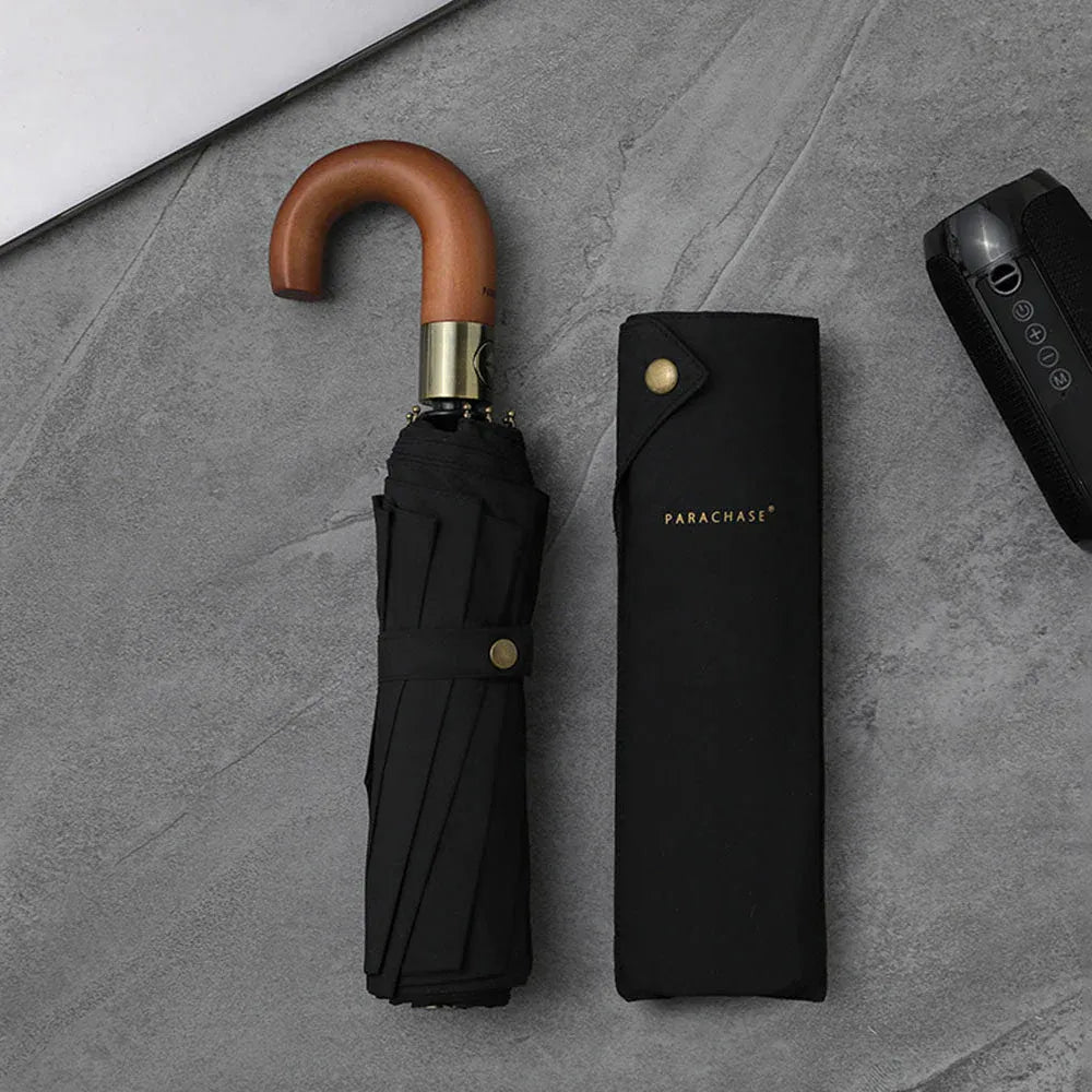 The foldable automatic umbrella with a wooden J-handle in black, shown closed next to its sleeve.