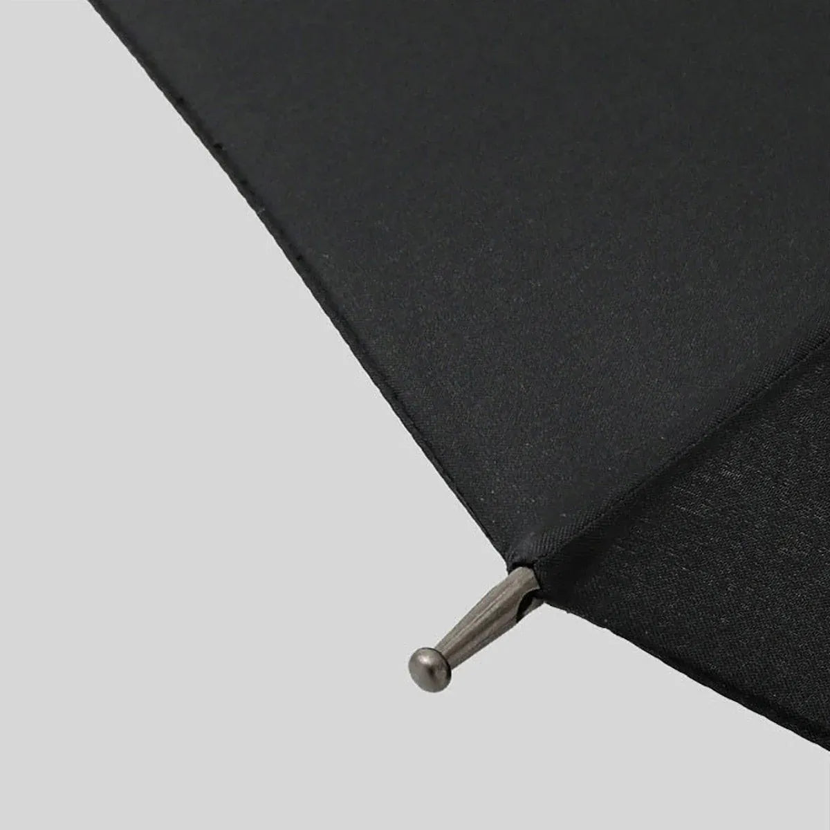 Detail shot of the metal tip on the edge of the black canopy of the Gentleman's umbrella.
