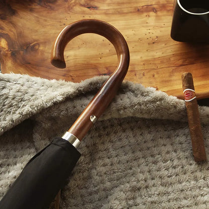 Lifestyle shot of the wooden crook handle next to a cigar on a textured surface.