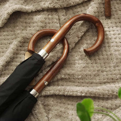 Close-up of two natural wood crook handles belonging to the Gents Black Umbrella.