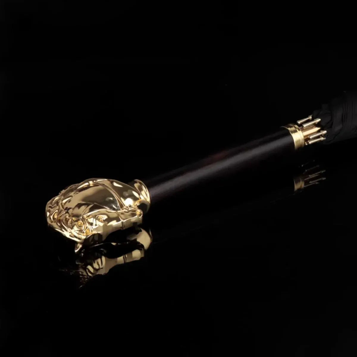 Artistic shot of the Gold Horse Handle umbrella handle reflecting on a dark, glossy surface.