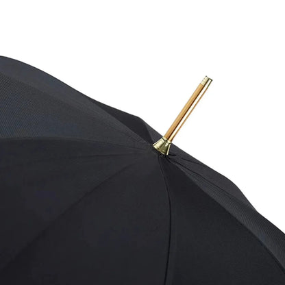 Close-up of the top of the open black canopy, showing the golden tip (ferrule).