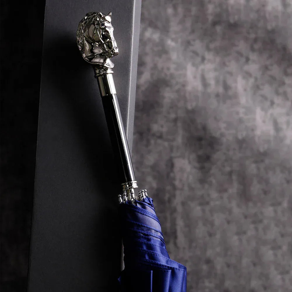 The elegant stick umbrella with a silver horse head handle, shown closed in blue.