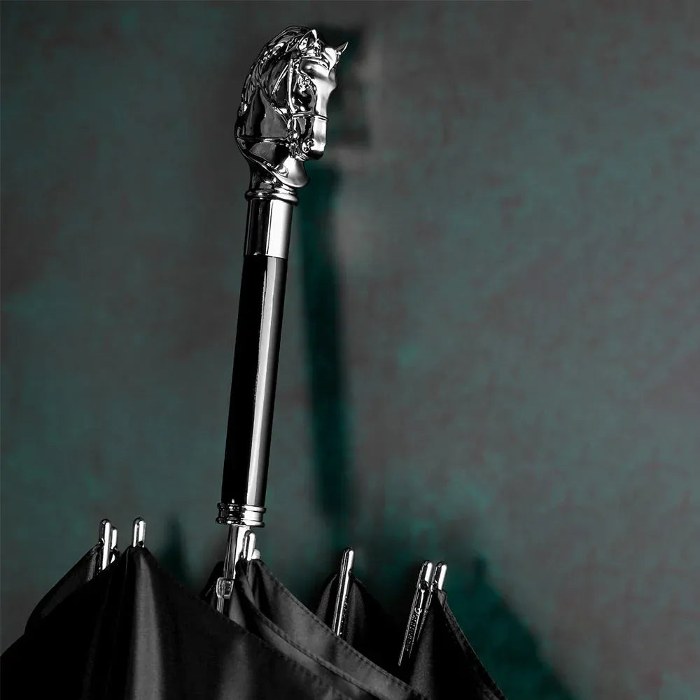 Detailed close-up of the silver horse head handle on the closed black umbrella shaft.