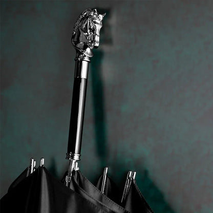 Detailed close-up of the silver horse head handle on the closed black umbrella shaft.