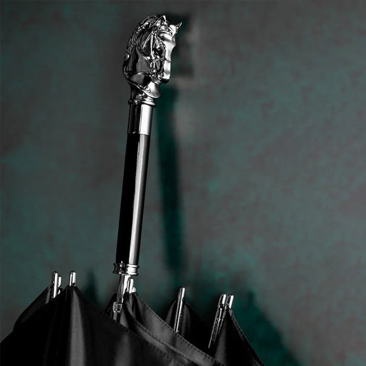 Detailed close-up of the silver horse head handle on the closed black umbrella shaft.