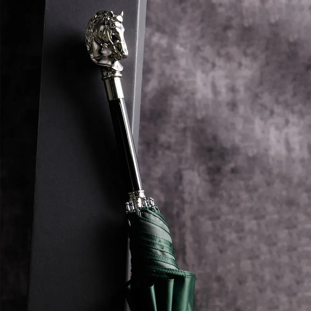 The elegant stick umbrella with a silver horse head handle, shown closed in green.