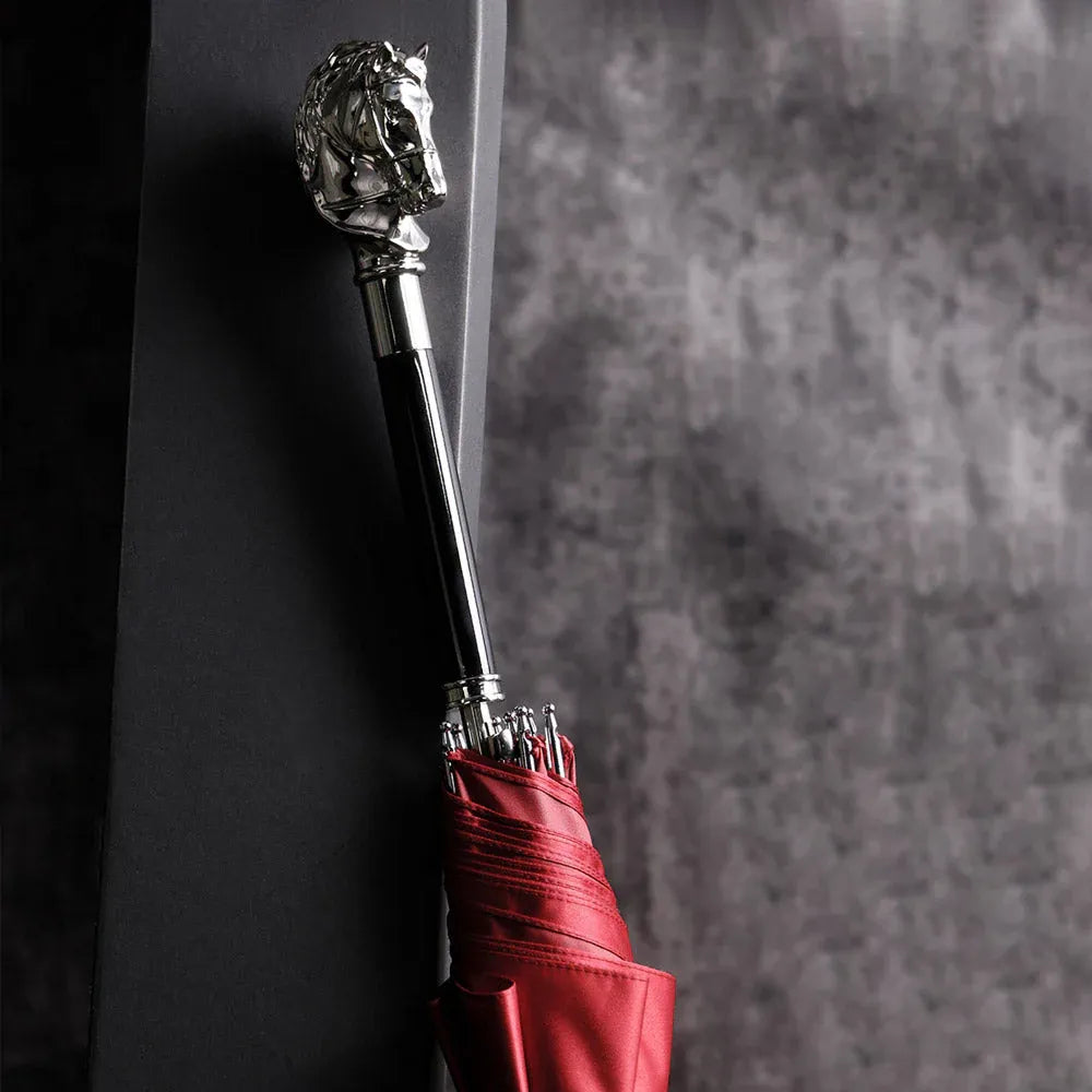 The elegant stick umbrella with a silver horse head handle, shown closed in red.