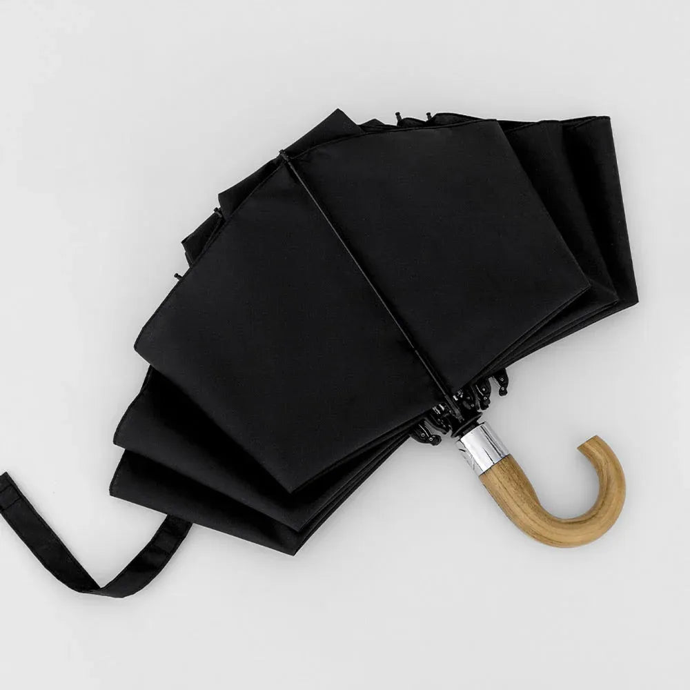 The black inverted umbrella partially closed, demonstrating the reverse folding mechanism.