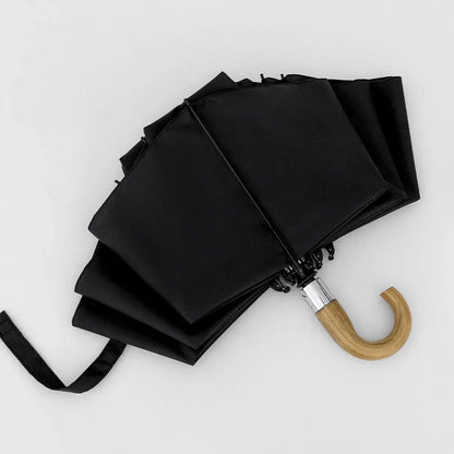 The black inverted umbrella partially closed, demonstrating the reverse folding mechanism.