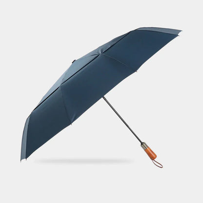 Full profile view of the open large automatic folding umbrella in navy blue with wood handle.