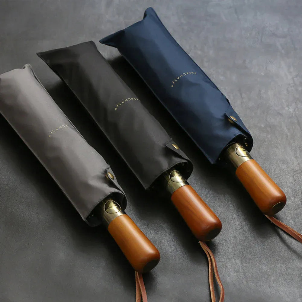 The grey, black, and navy blue large folding umbrellas shown partially inside their sleeves.